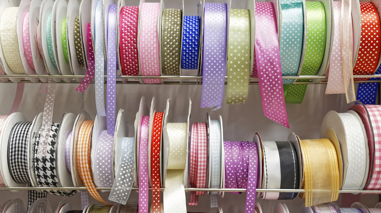 Rolls of assorted fabric ribbons sitting on shelves.