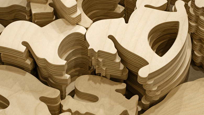 Stacks of unpainted wood cutouts in a rocking horse design.