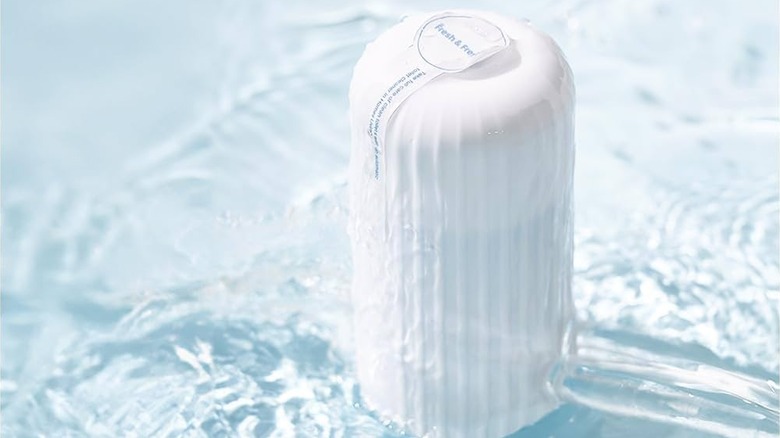 A white automatic cleaner surrounded by water
