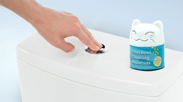 A hand flushing the toilet with a Simple Life toilet bowl cleaner on the side