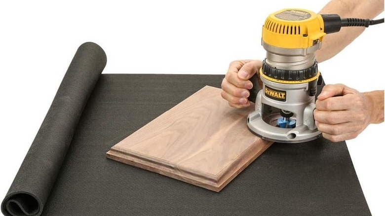 A person putting an anti-vibration pad under a washing machine