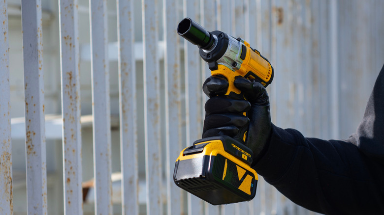 A person holding an impact driver