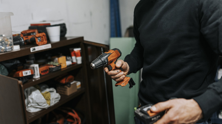 A person changing the battery on a drill