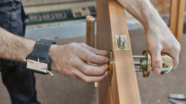 A person working on a door wearing a magnetic wristband