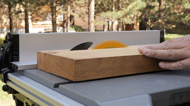 A person cutting wood with a table saw