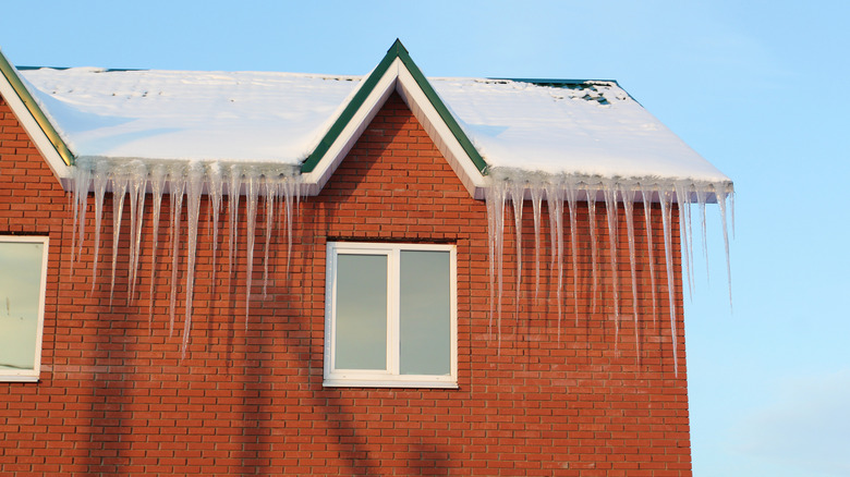 Icicles hanging from roof of brick house