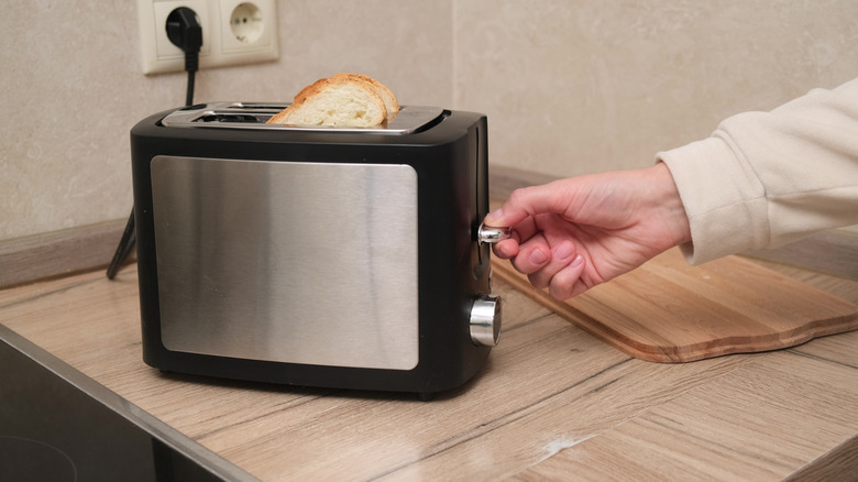 A man switching on a toaster