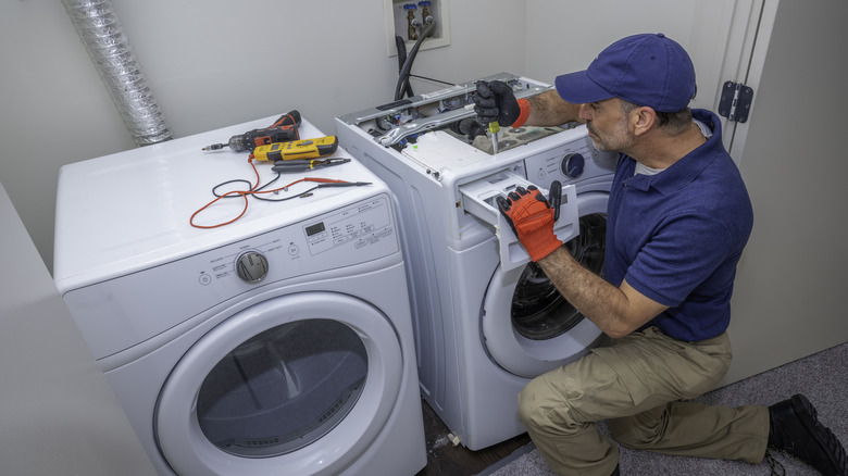 An appliance technician working on a washing machine