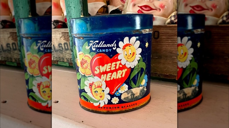 blue and red vintage Kiellands Candy tin on counter