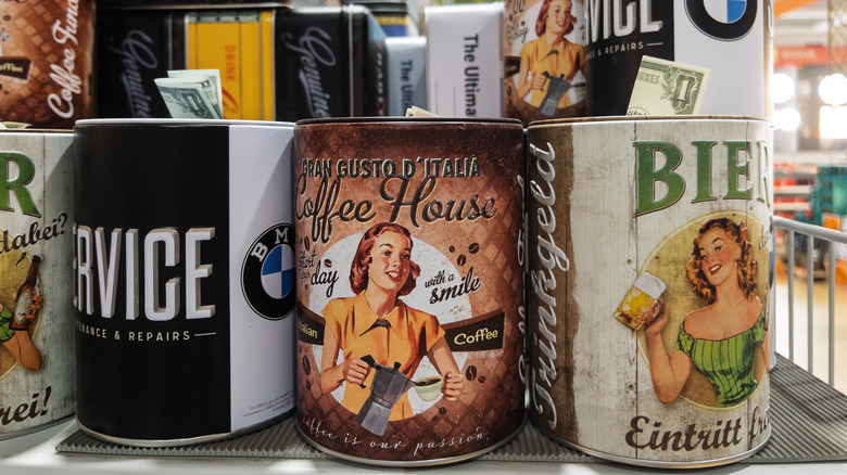vintage coffee tins on shelf with money coming out of them