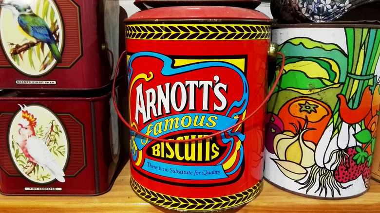 vintage red biscuit tin on shelf with other tins