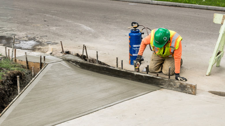 Worker laying driveway slope