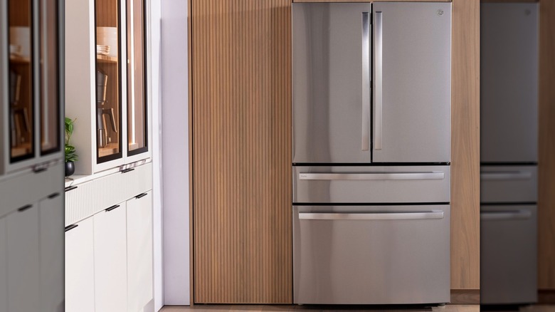 A stainless steel fridge against a wood backdrop