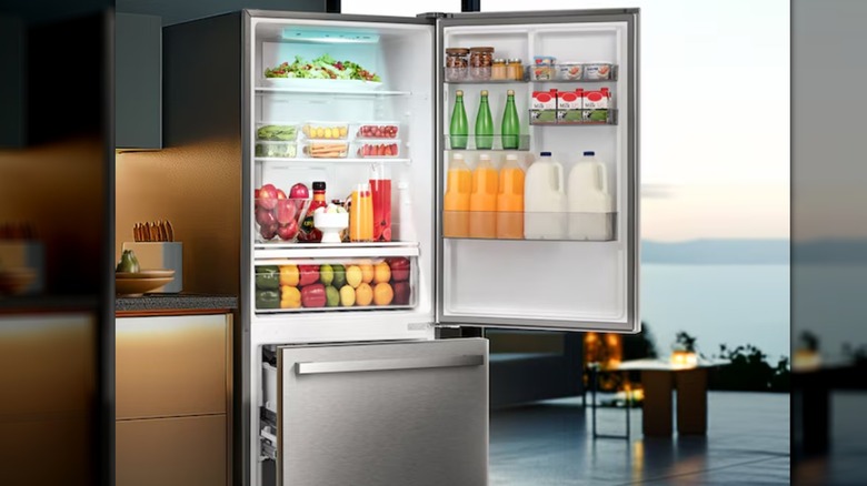 A fridge with its door open and bottom shelf pulled out