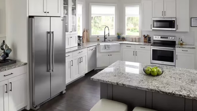 A stainless steel fridge in a modern kitchen with a neutral color palette