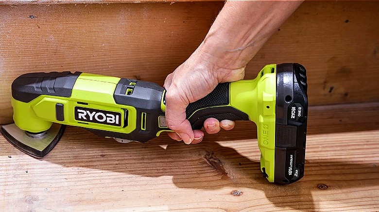 A person using a multi-tool on some wooden steps