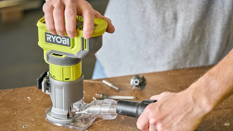 Person using a Ryobi router attached to a vacuum