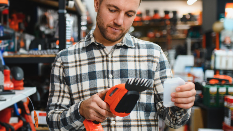 Man choosing gardening shears in a gardening store