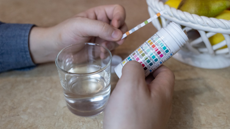 Individual testing water using pH strips
