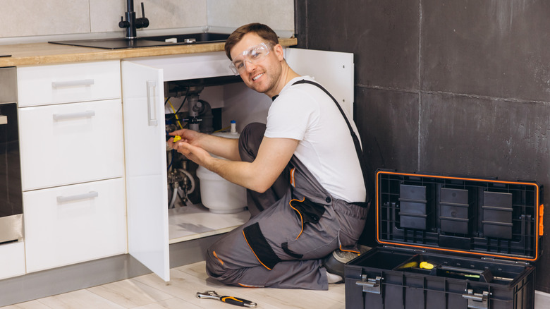 Plumber working under a sink