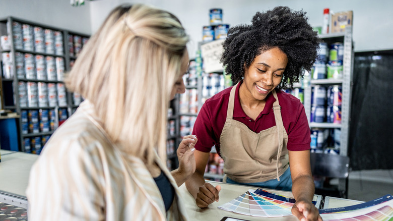 Woman looking at paint with a salesperson