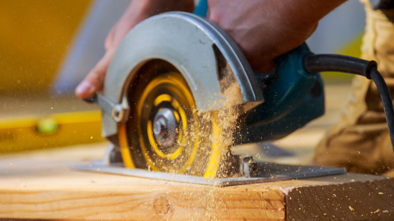 Man using a circular saw to cut boards