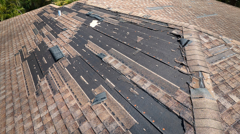 Damaged roof with broken and missing shingles