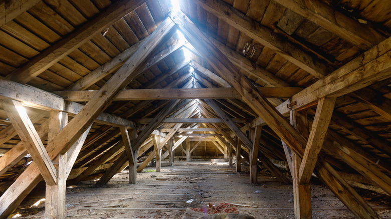 The attic of an old house, light shining through gap in the apex of roof