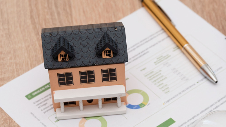 Energy bill on desk with model house and pen