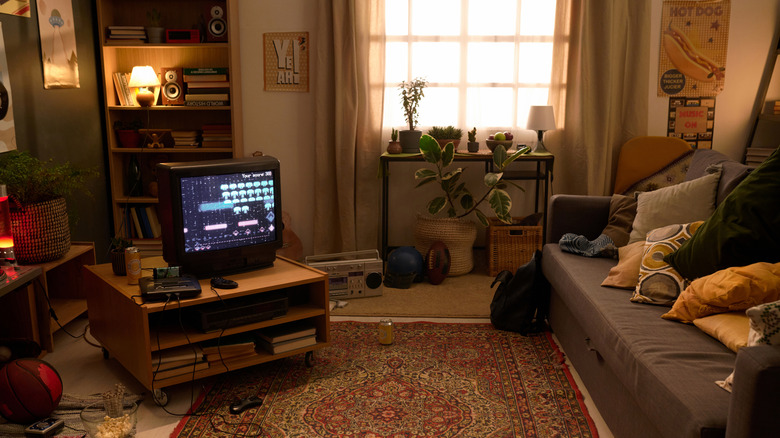 Modern living room with a wall-mounted TV, a wood accent wall, and white furniture.