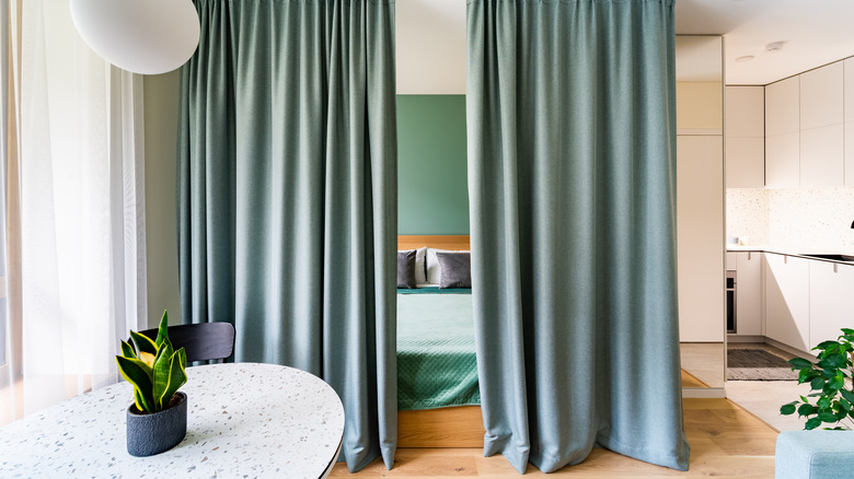 A curtain sectioning off bed from the rest of the apartment