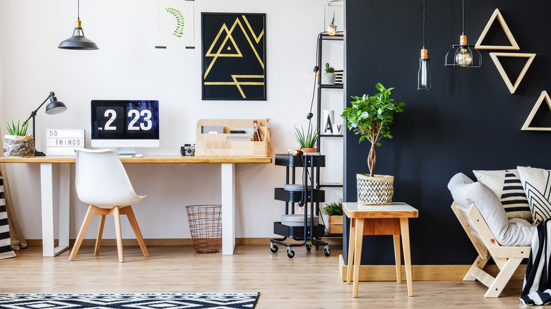 A study area with white wall sectioned off from living area with black wall