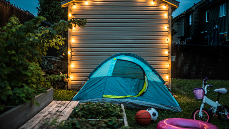 A night-time scene showing a garden shed with kids toys in front of it