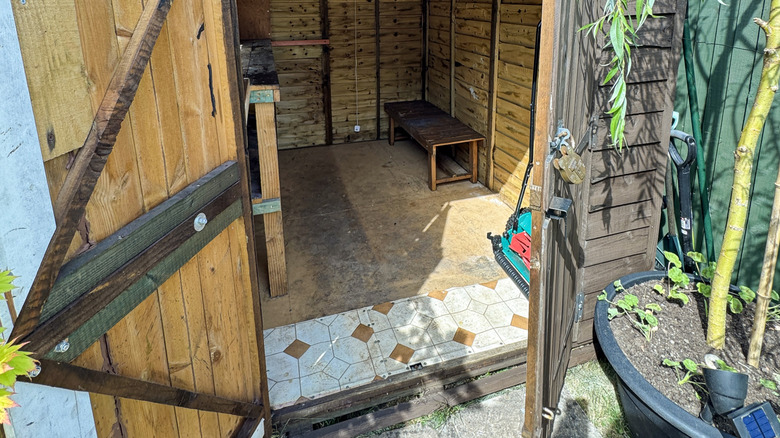 A shed floor with a strip of vinyl flooring over the main floor