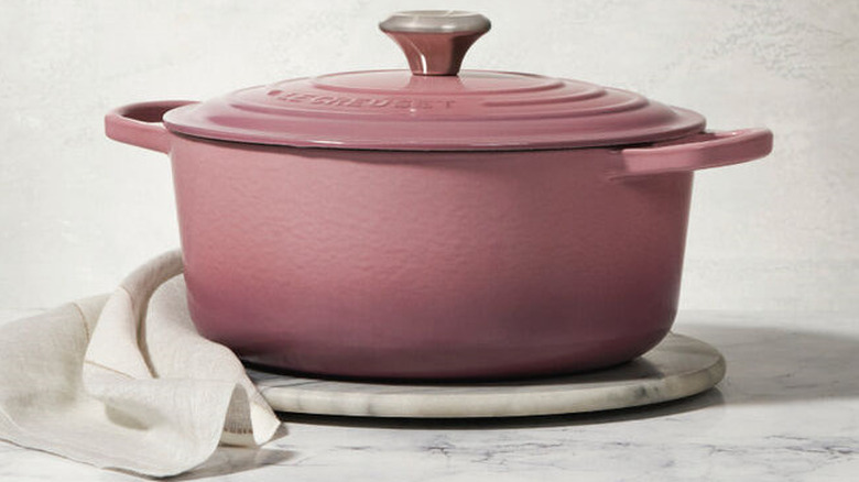 A round dutch oven in a pink mauve shade.