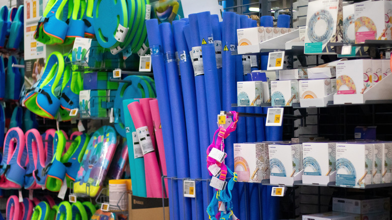 A vibrant display of colorful pool accessories and toys, including pool noodles