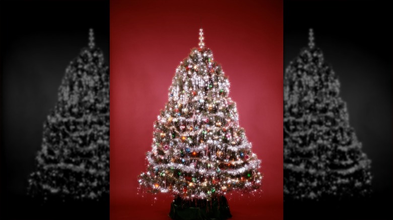 A bright, colorful Christmas tree from the 1980s on a red background