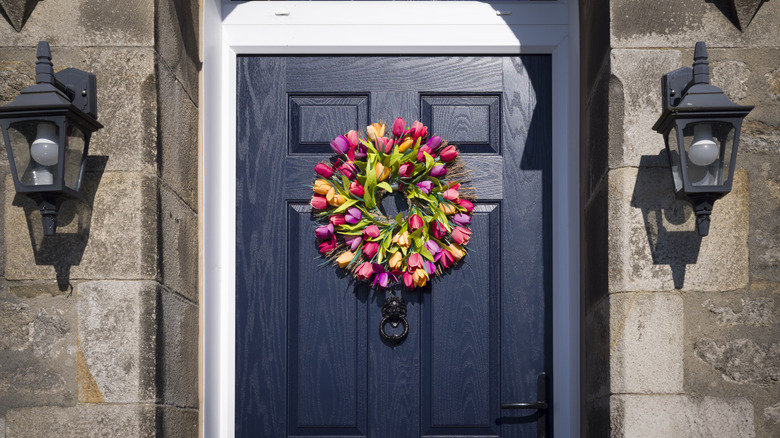Brightly colored tulip wreath hung on a home's front door