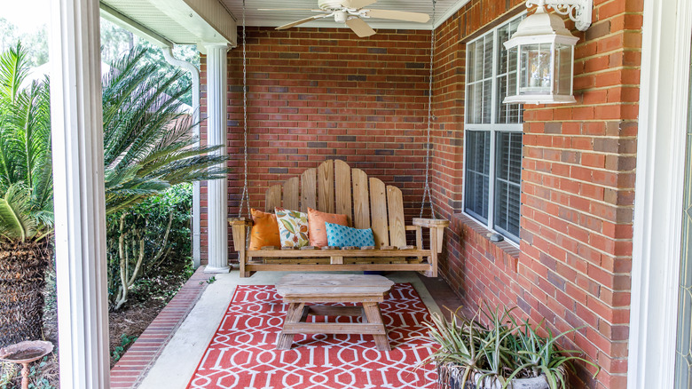 Bohemian front porch with porch swing and a red patterned rug