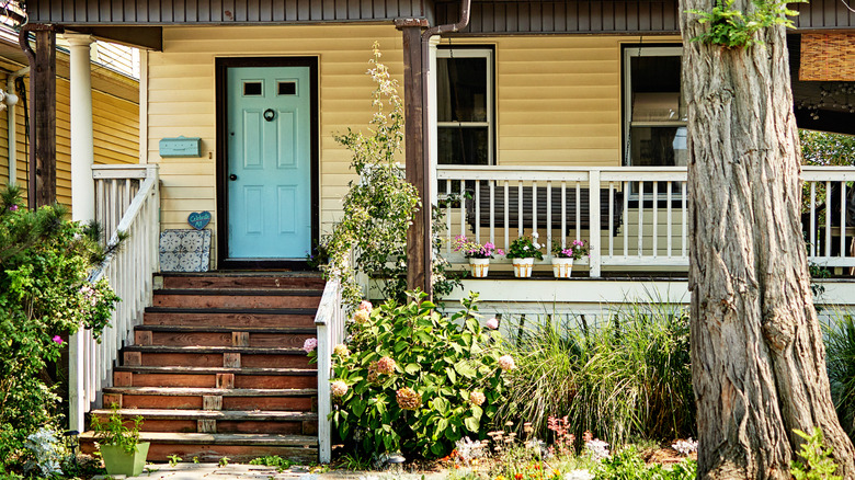 A yellow house exterior with a bright blue door