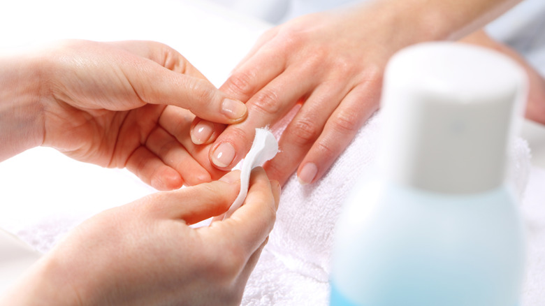 A person using Acetone on their hands 