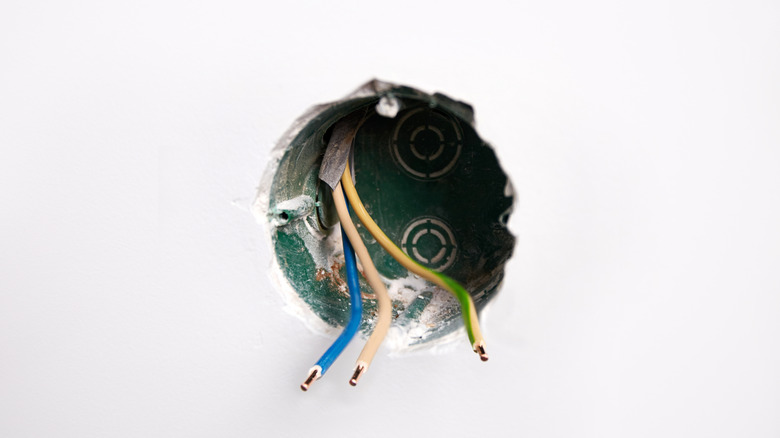 A circular hole in the wall where electric is installed