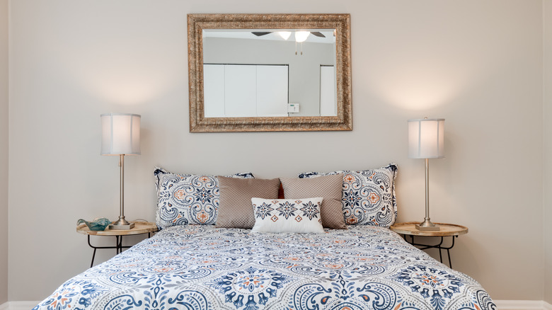 Mirror hanging above bed