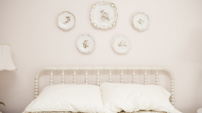 Decorative plates hanging above a bed