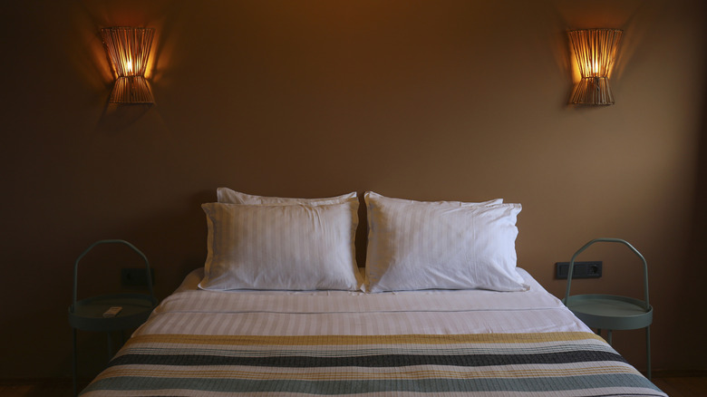 Rattan sconces above a bed
