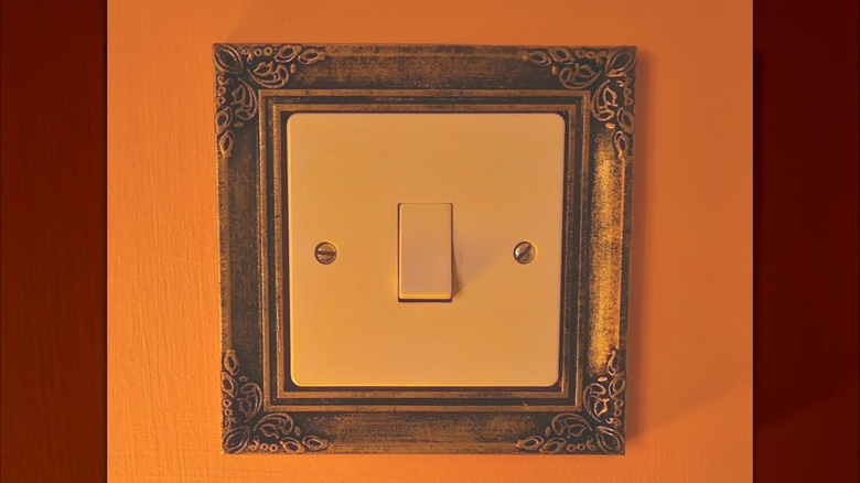 Guilded frame over a light switch plate