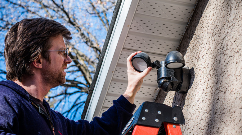Man cleaning an outdoor light fixture