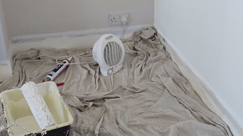 A small fan being used to dry a painted wall