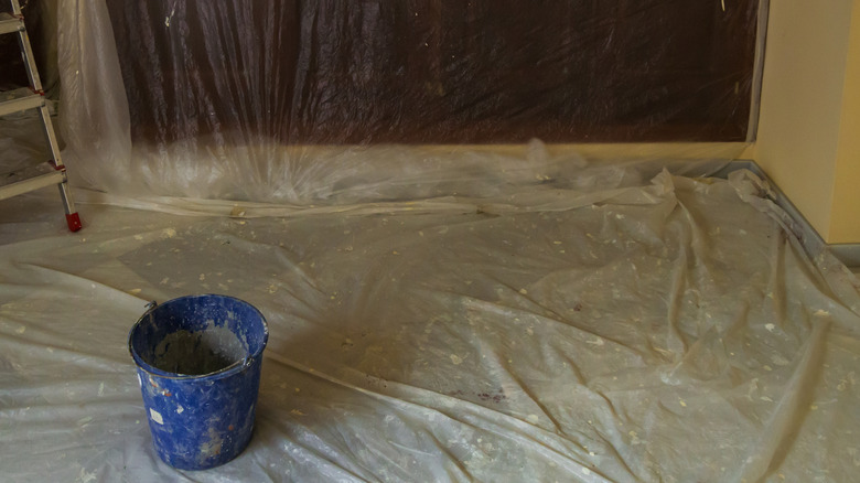 Paint sheeting protecting a floor with a blue bucket