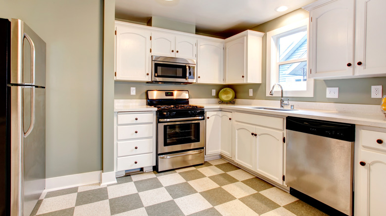 A kitchen with gray checkerboard floor tiles